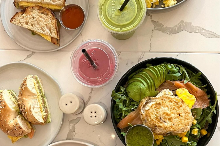 This photo features a brunch spread with various sandwiches and drinks. 