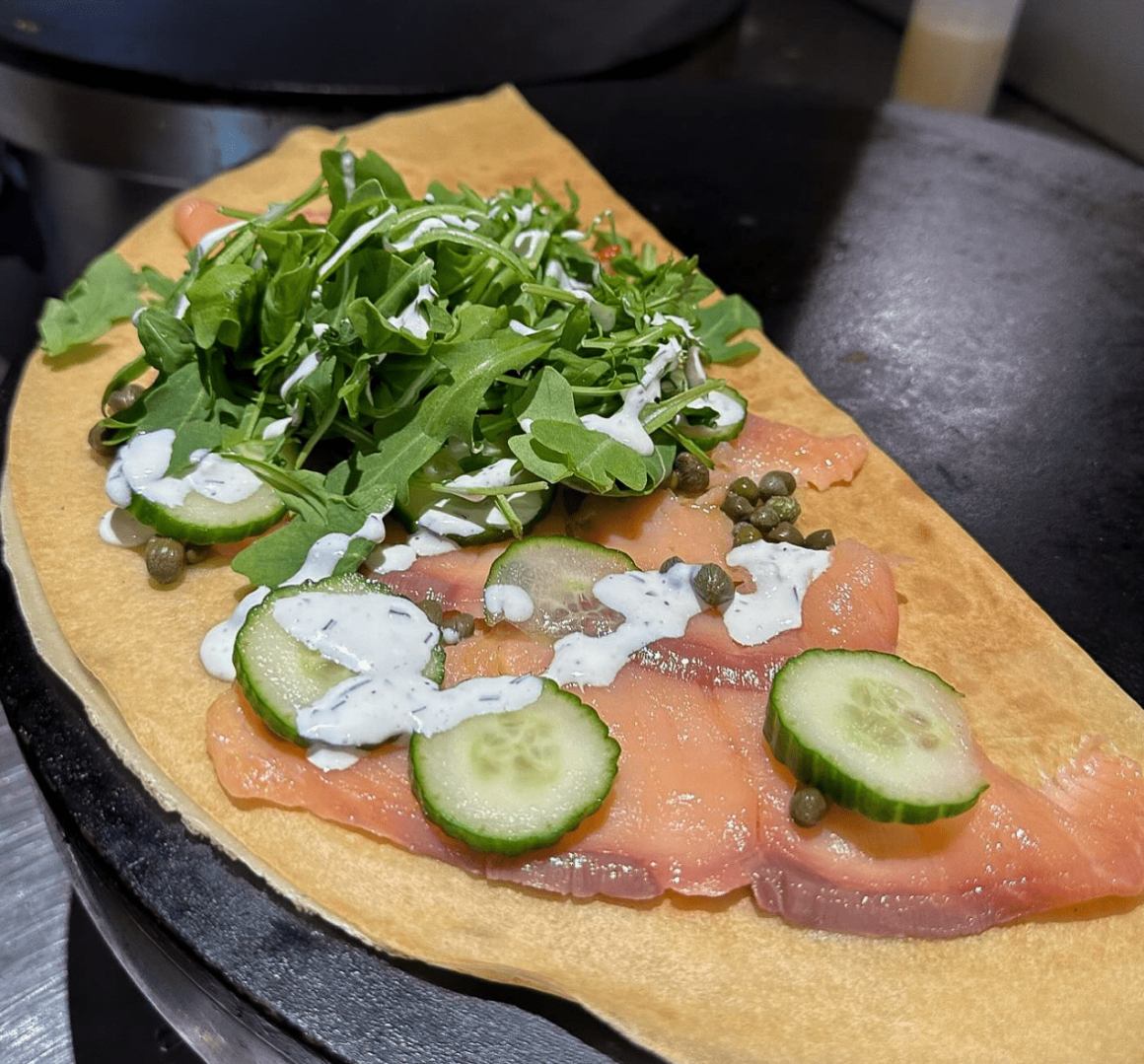 This is an image of a Mr. Crepe SUPER Special crepe:  Smoked salmon • Red onions • Cucumbers • Capers • Baby arugula • Sour cream