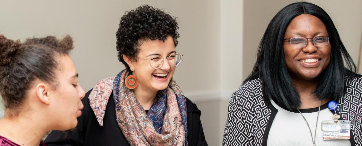 Three woman with different racial and ethnic identities laugh together at a Diversity Reception