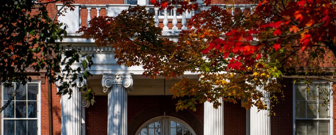 Autumn leaves frame the columned entrance to Ballou Hall