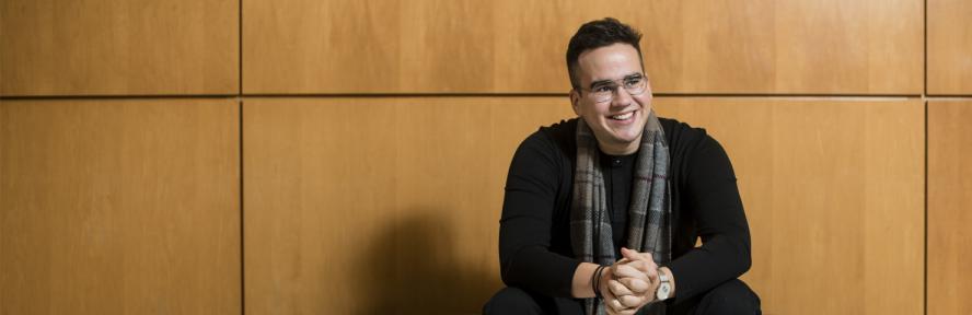 Jonathan Diaz sits with hands crossed in the Tufts Granoff Music Center.