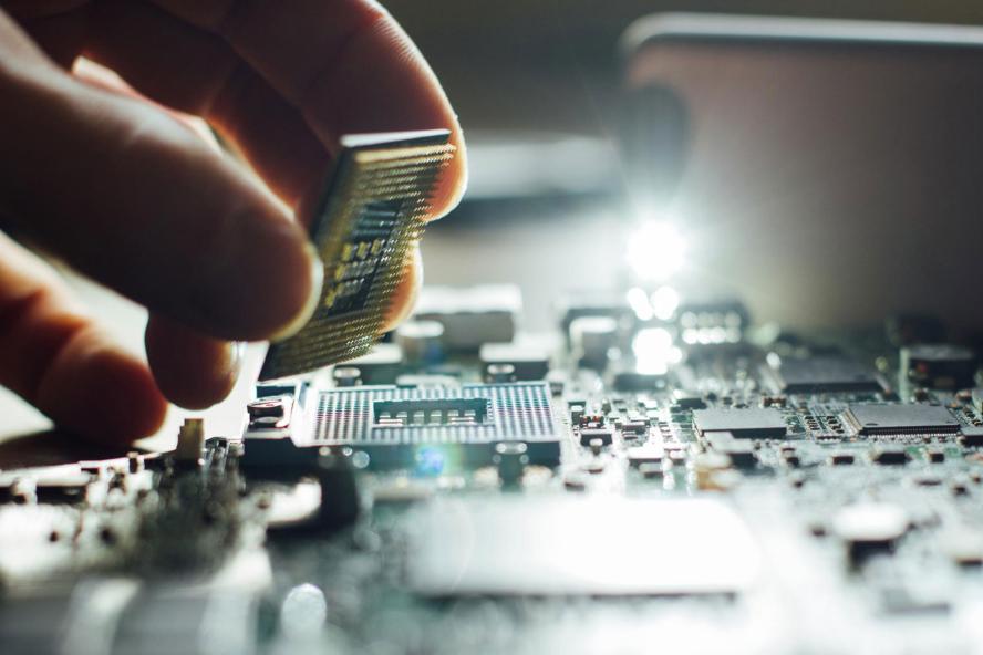A scientist places a computer chip into a circuit board