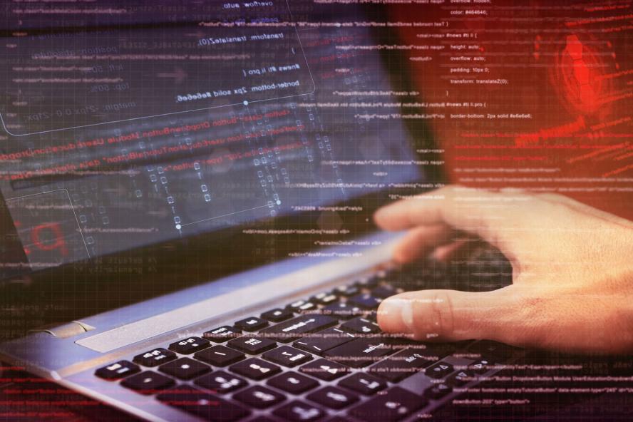 Typing on a laptop with strands of code overlayed
