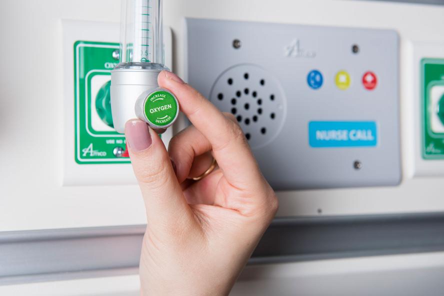 A hand turning a knob on a switchboard