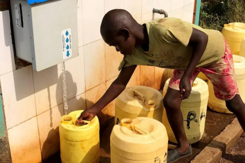 A young boy gets water from a neighborhood spigot in Uganda. A Tufts study shows low-cost water purification, which can save lives from waterborne diseases, does not harm beneficial bacteria in children’s guts