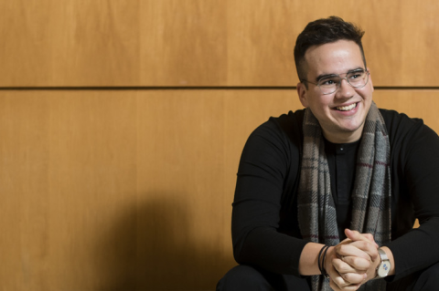Jonathan Diaz sits with hands crossed in the Tufts Granoff Music Center.