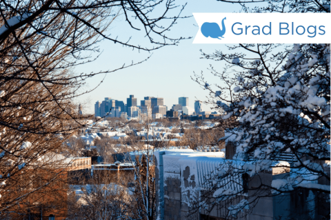 A snowy Boston skyline is in the distance from the Tufts library rooftop.