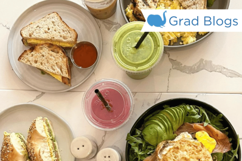 Image of food on a table featuring smoothies, salads, and sandwhiches